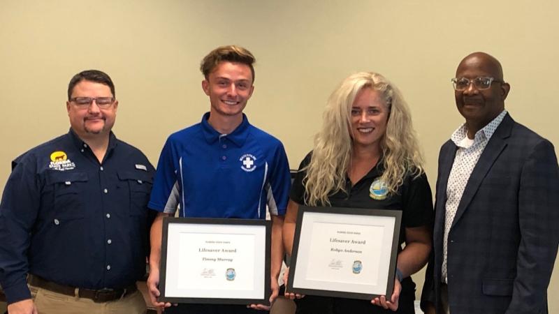 Brian Fugate and BJ Givens present a 2022 Lifesaver Award to Robyn Anderson and Timmy Murray.